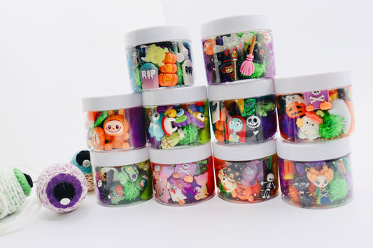 Stack of colorful toy containers with Halloween-themed designs on a white background