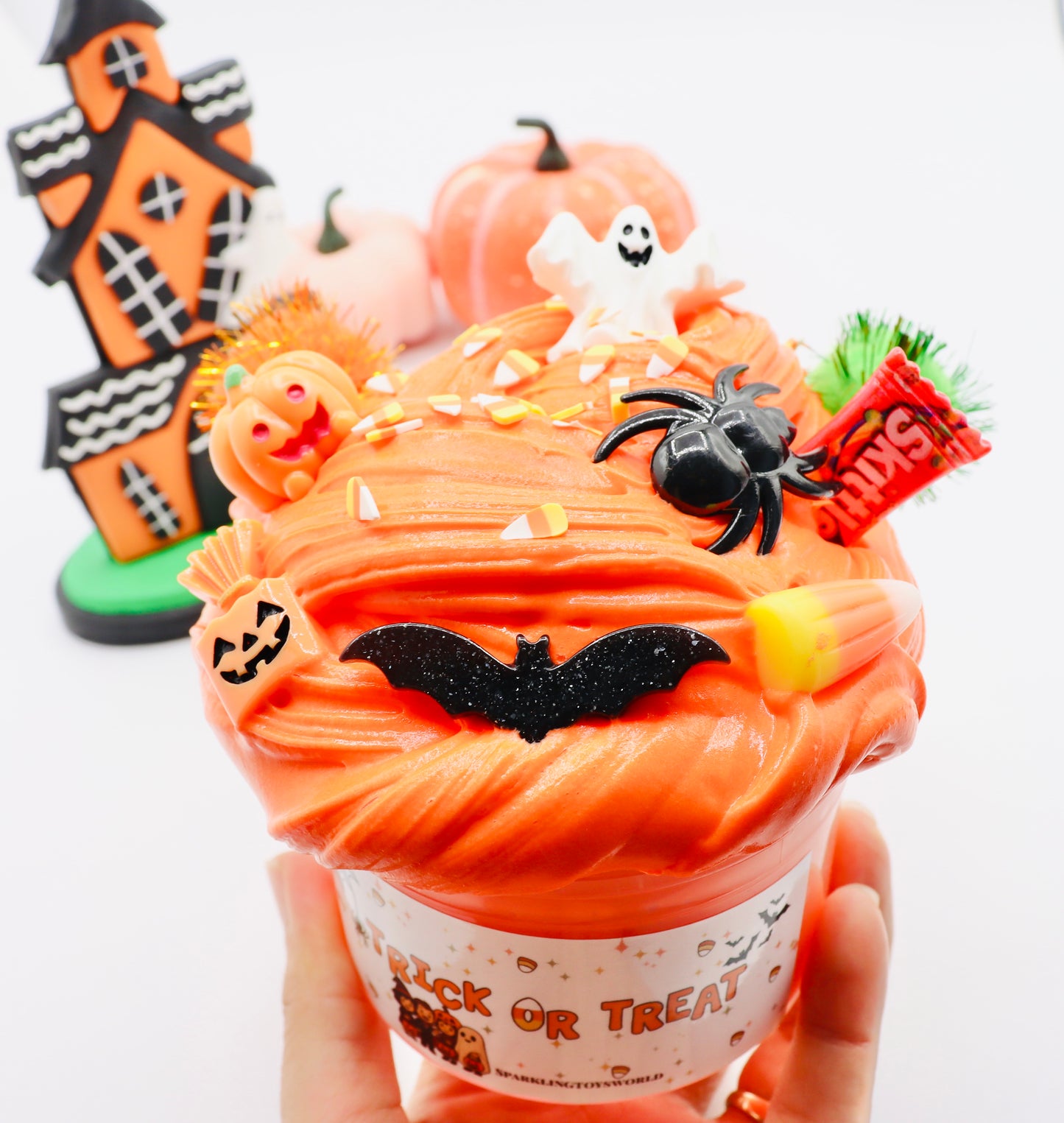 Halloween-themed cupcake with decorations including a ghost, spider, and candy corn.