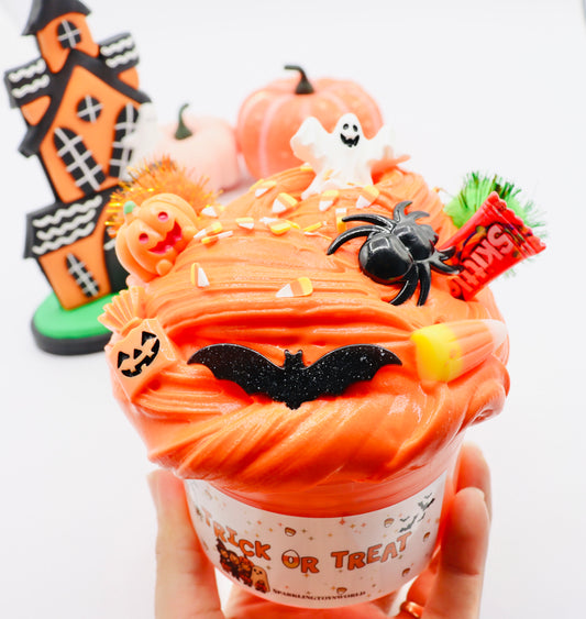 Halloween-themed cupcake with decorations including a ghost, spider, and candy corn.